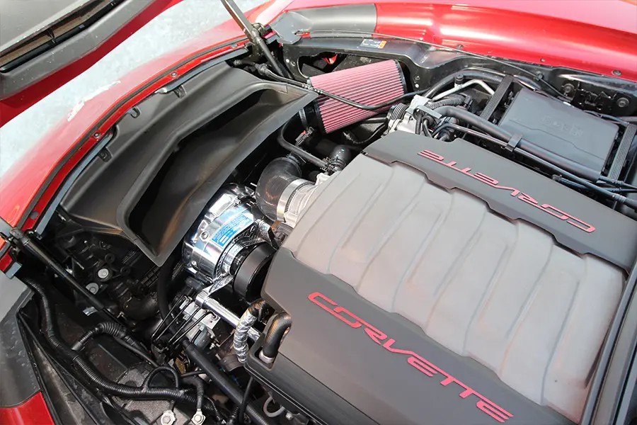 Polished ProCharger head unit installed in a red C7 Corvette LT1 engine bay